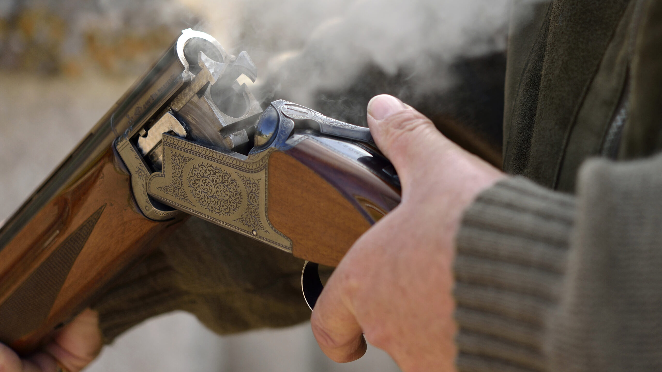 A 12 gauge shotgun smoking after opening and ejecting a cartridge